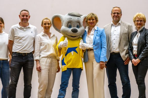 V.l.n.r.: Bettina Lohrer (Schulsozialarbeiterin), Björn Drzalek (Förderverein der Friederike-Brion-Grundschule), Marlene Haßler (Schulleiterin), Ed Euromaus, Mauritia Mack, Alexander Schröder (Bürgermeister) und Ludwina Geiger (einfach helfen e.V.)